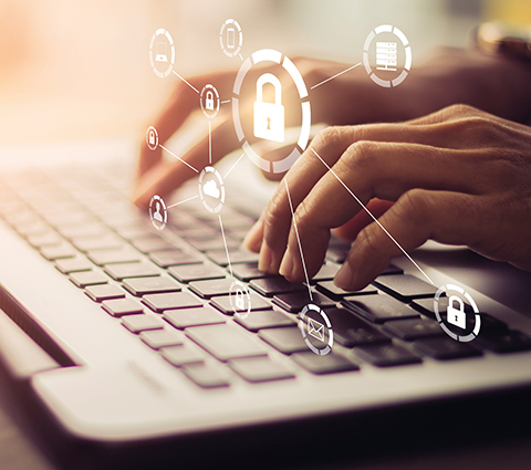 Hände tippen auf Tastatur mit Sicherheitssymbolen