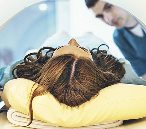 Frau liegt in einem MRT.