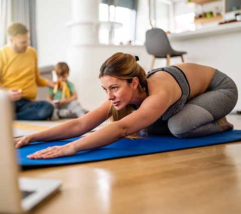 Frau macht Yoga im Wohnzimmer