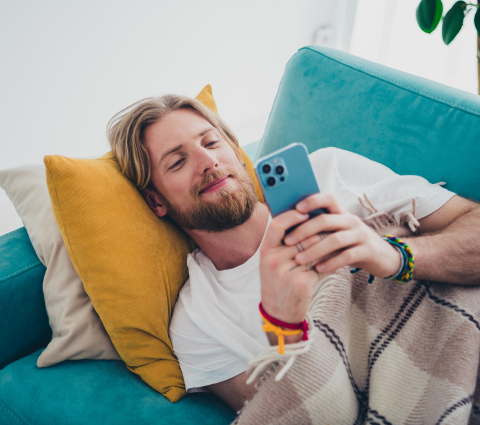 Mann mit Bart liest auf seinem Smartphone.