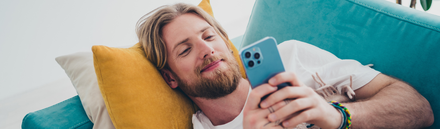 Mann mit Bart liest auf seinem Smartphone.