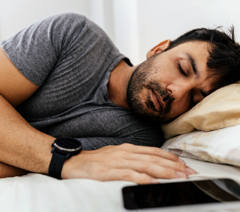 Mann tief schlafend im Bett.