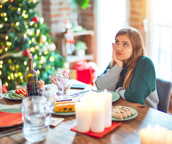 Junge Frau traurig beim Weihnachtsessen